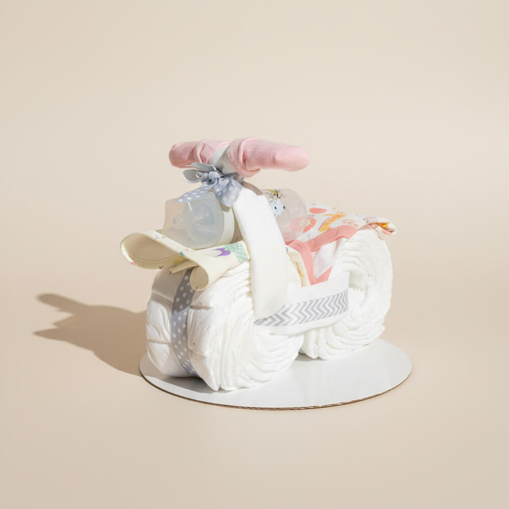 Blemotorcykel i lyserød farve med babyprodukter som sød gave til pige