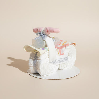 Blemotorcykel i lyserød farve med babyprodukter som sød gave til pige