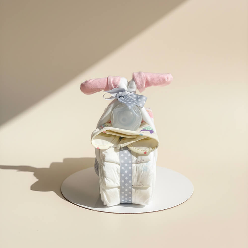 Lyserød blemotorcykel pyntet med bamse og bleer som gave til babyshower