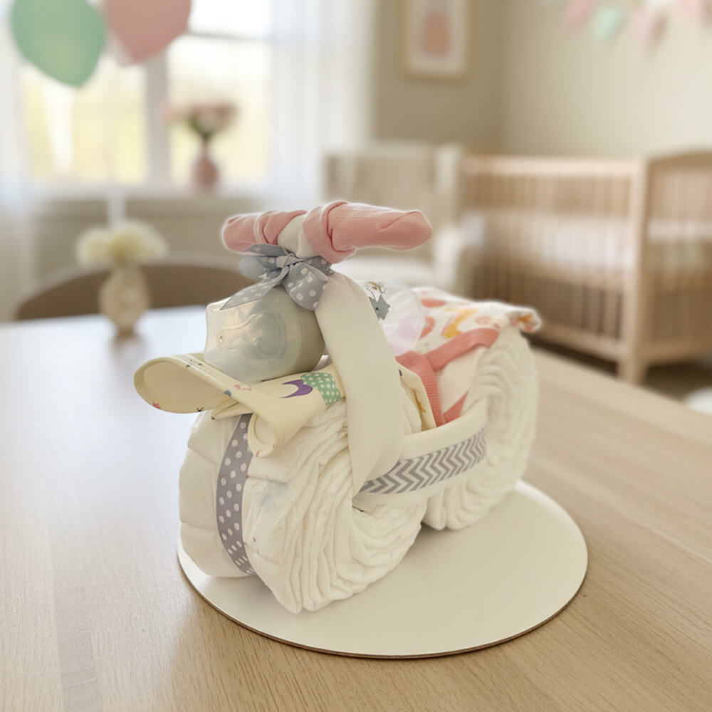 Blemotorcykel i lyserød farve med babyprodukter som sjov gave til pige