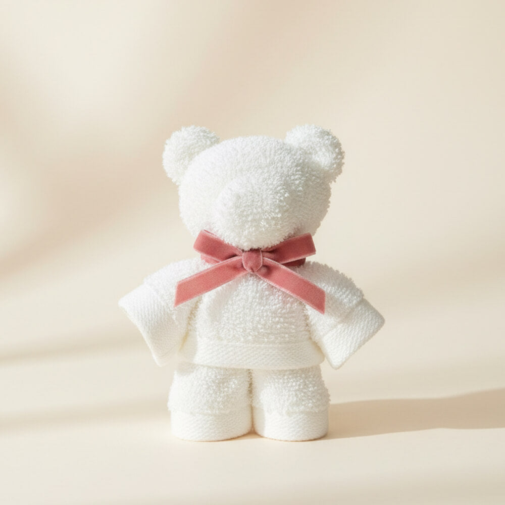 Hvid håndklædebamse med lyserød bånd som sød gave til babyshower eller barsel