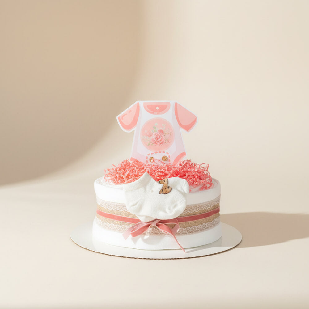 Lyserød lille blekage pyntet med bånd og bamse som gave til pige