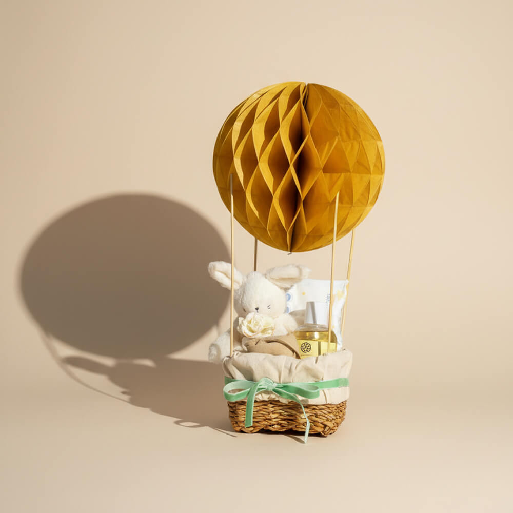 Neutral luftballon gavekurv i lyse farver med bamse og babyprodukter