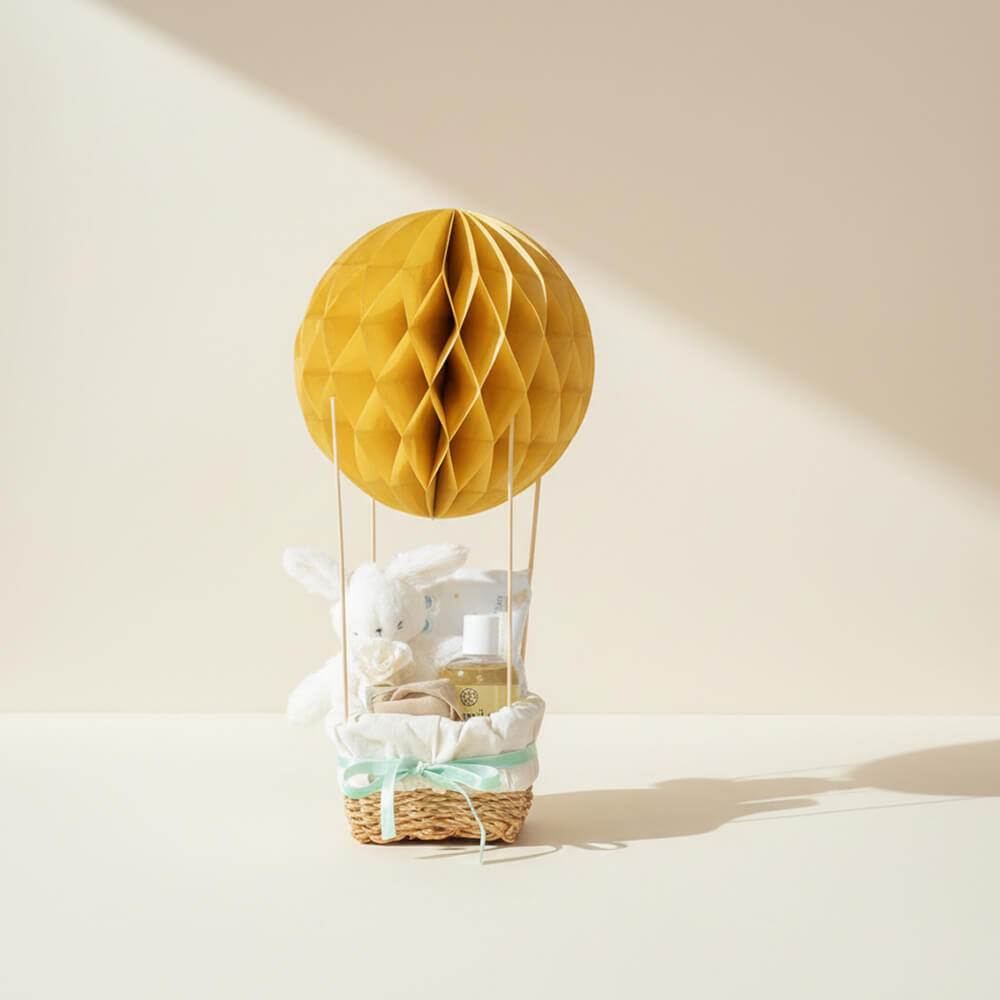 Neutral luftballon gavekurv med gyldne nuancer som elegant gave til babyshower