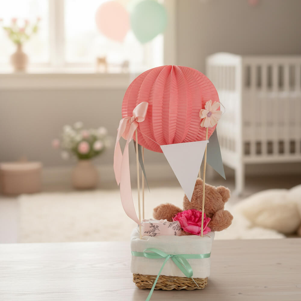 Lyserød luftballon-gavekurv med bamse og babyprodukter